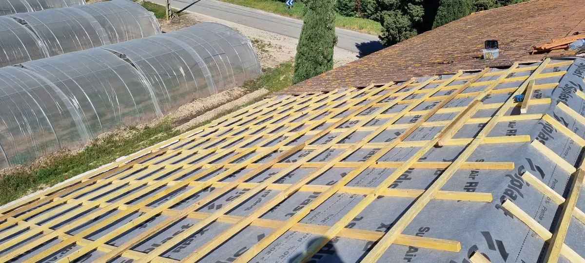 Réfection de toiture en cours à Carpentras : écran sous-toiture posé, liteaux cloués sur contre-liteaux, ancienne couverture encore en place en haut du toit