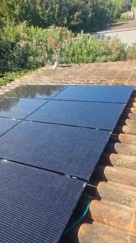 Panneaux solaires propres posés sur une toiture en tuiles, après nettoyage